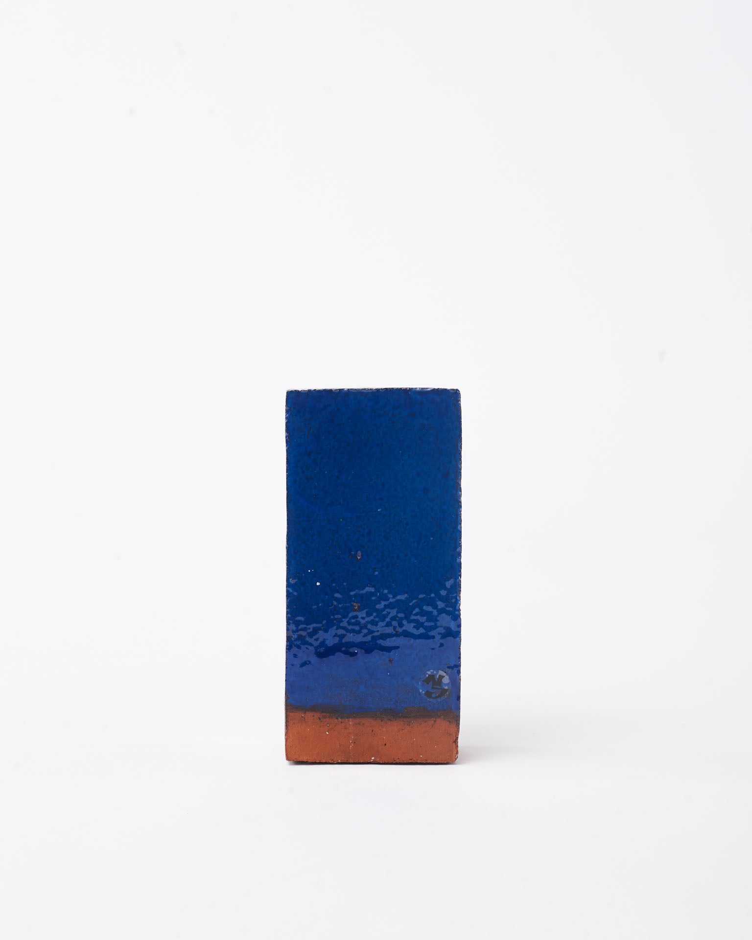 Handmade dark blue brick ceramic candle holder in white glaze in white background